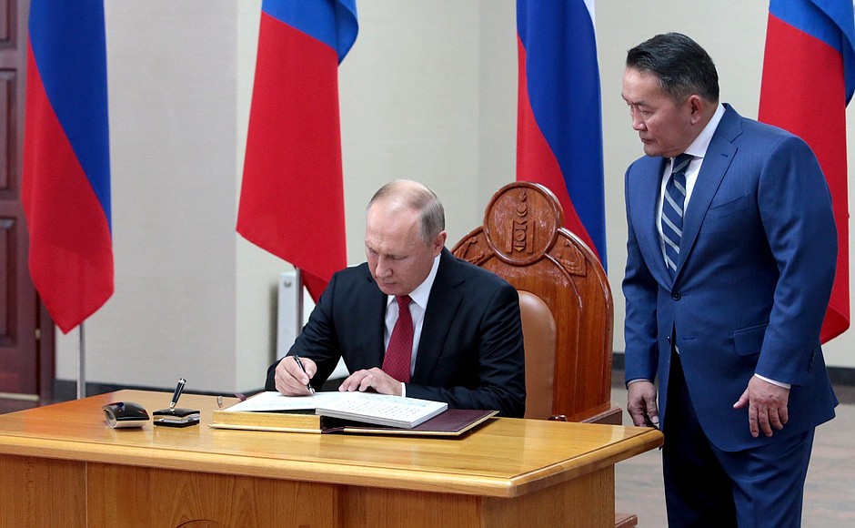 Vladimir Putin signs the distinguished visitors’ book. With President of Mongolia Khaltmaagiin Battulga.