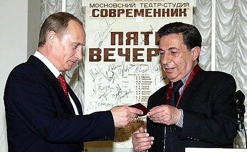 Actor Igor Kvasha handing the President a staff-pass to the theatre.