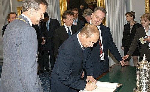 President Putin making an entry to the Signet Library honoured guests book. In the background is First Minister of Scotland Jack MacConnell.