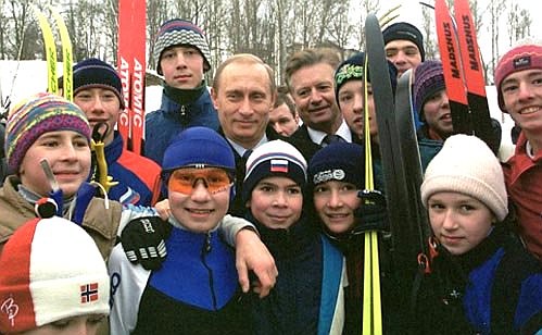 President Putin inspects ski stadium. President Putin with young athletes.