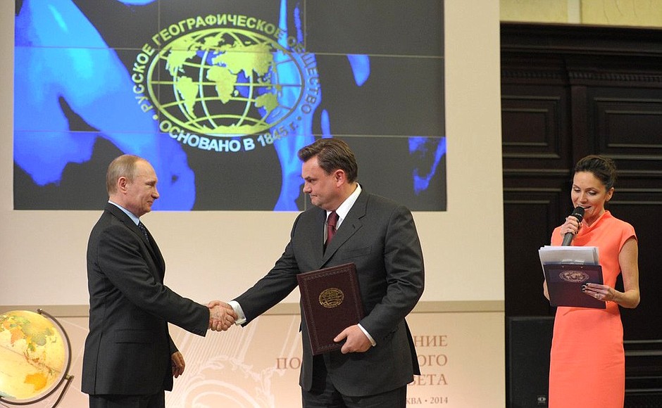 Vladimir Putin presents a certificate of the Russian Geographical Society Board of Trustees member to Supervisory Board Chairman of the Centre for the Study and Conservation of the Amur Tiger, Presidential Aide, Head of the Presidential Control Directorate Konstantin Chuychenko.