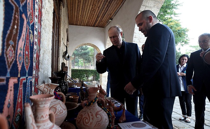 At the Naryn-Kala citadel, Vladimir Putin looks over the exhibit of folk crafts.