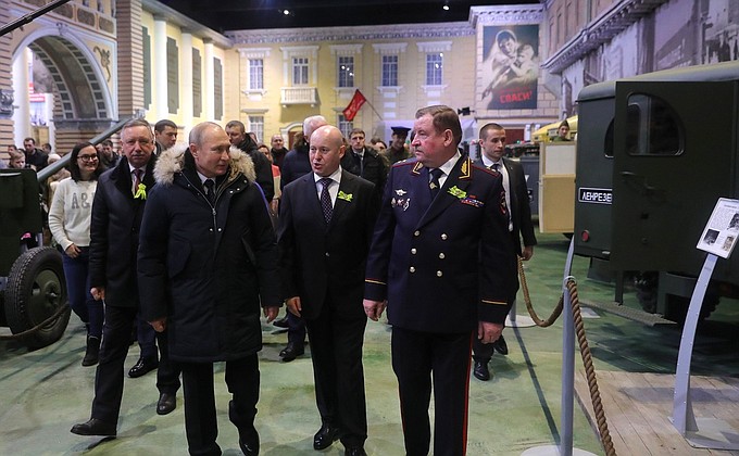 During a tour of an exhibit organized by the Lenrezerv patriotic association for the 75the anniversary of the complete liberation of Leningrad from the Nazi siege. With Acting Governor of St Petersburg Alexander Beglov. Left, Lenrezerv founder Anatoly Bernshtein, centre, and Head of the Russian Interior Ministry's Directorate in St. Petersburg and the Leningrad Region Sergei Umnov.