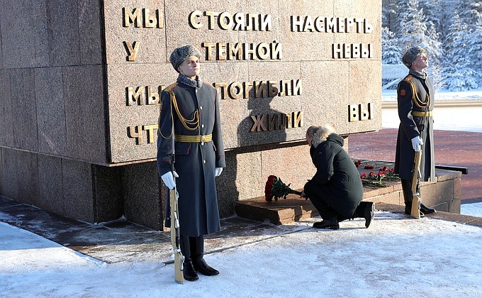 Laying flowers at the Landmark Stone monument at the Nevsky Pyatachok military historical memorial.