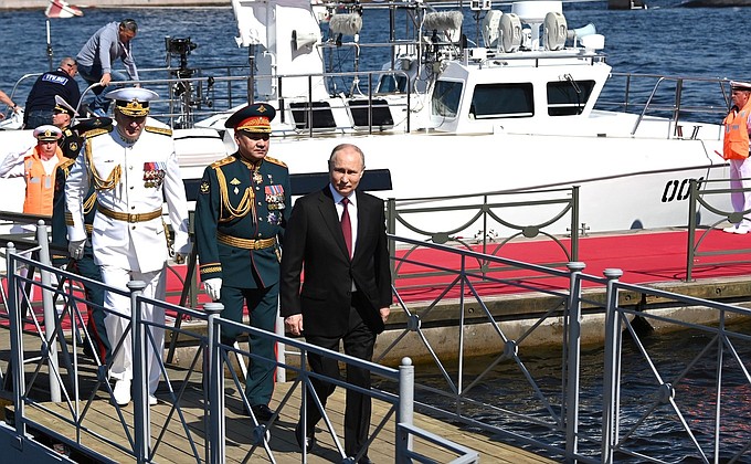 The Supreme Commander-in-Chief from a cutter reviewed fleet formations, lined up for the parade. With Defence Minister Sergei Shoigu (second left) and Commander-in-Chief of the Navy Nikolai Yevmenov.