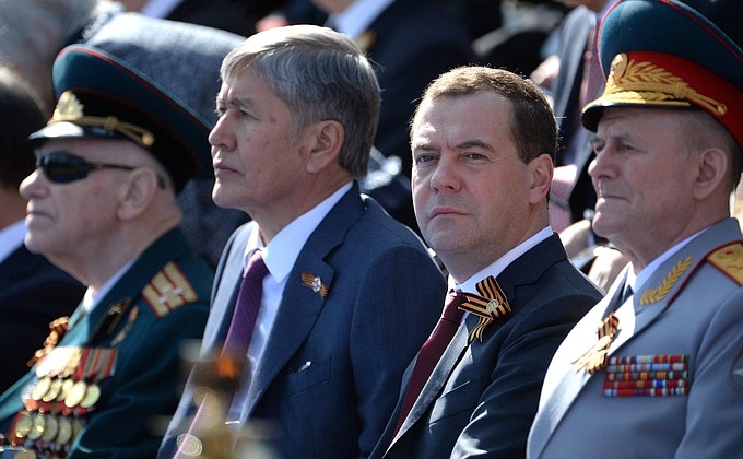 Председатель Правительства РФ Дмитрий Медведев и президент Киргизской Республики Алмазбек Атамбаев (второй слева) во время военного парада. Фото: may9.ru.