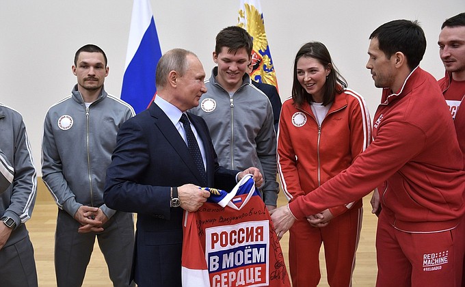 Pavel Datsyuk, captain of the Russian Olympic ice hockey team, presents Vladimir Putin with a sweater with the Russia In My Heart logo, signed by the team members.