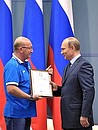 Vladimir Putin awards a commendation to Pavel Balsky for his services to developing physical culture and sport.