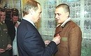 Vladimir Putin decorating a serviceman who took part in the counter-terrorist operation in the North Caucasus with the Zhukov medal.