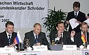 President Putin with German Chancellor Gerhard Schroeder and Russia\'s Economic Development and Trade Minister German Gref (left) at a meeting with Russian and German businessmen.