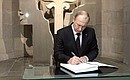 Vladimir Putin signs the distinguished visitors' book at the Tsitsernakaberd Armenian Genocide Memorial Complex.