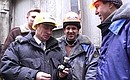 Vladimir Putin visiting an operating drilling tower near Surgut. A flask of Surgut oil is a workers\' gift.