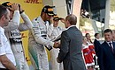Vladimir Putin presented the cup to Lewis Hamilton, winner of the Russian stage of the Formula One World Championship.