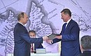 Vladimir Putin presents a certificate of election to the Russian Geographical Society’s Board of Trustees to Chief of Staff of the Presidential Executive Office Sergei Ivanov.