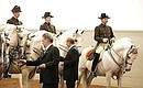 В Испанской школе верховой езды. После показательного выступления наездников Владимир Путин с Федеральным президентом Австрии Хайнцем Фишером вышли на манеж и угостили лошадей кусочками сахара.