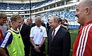 Vladimir Putin talks with young football players during his visit to Kaliningrad Stadium.