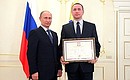 Presenting state decorations. Igor Ivlev, deputy chairman of the board of the Poisk national public organisation for immortalising the memory of those who fell defending the Fatherland, receives an honorary certificate from the President.