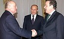 During a meeting with German Chancellor Gerhard Schroeder. Russian prime Minister Mikhail Fradkov is on the left.