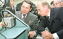 Visiting the Sukhoi Aviation Military Industrial Complex. President Putin in an avionics laboratory with test pilot and Hero of Russia Igor Votintsev.