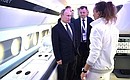 Vladimir Putin looks over a model of the Sukhoi SportJet interior at the International Aviation and Space Salon MAKS-2017.