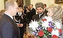 Members of the Chechen family of Tashukhadzhiyevs being decorated for their heroic behaviour in a clash with criminals. President Putin with Raisa Tashikhadzhiyeva.
