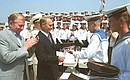 President Putin with Ukrainian President Leonid Kuchma on board the Russian Black Sea Fleet\'s flagship the Moskva missile cruiser. A gift from navymen, sailors caps and striped vests.