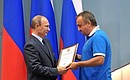 Vladimir Putin awards a commendation to Andrei Safronov for his services to developing physical culture and sport.