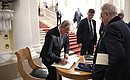 Vladimir Putin signs the distinguished visitors’ book at the State Hermitage. On the right: Director of the State Hermitage Mikhail Piotrovsky.