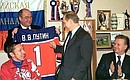 President Putin meets with members of the Russian Olympic select team. Alexander Steblin, President of the Russian Ice Hockey Federation (centre), presents a hockey player\'s sweater to Putin.