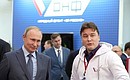 Vladimir Putin visited the Russian Popular Front space at the International Volunteer Forum. With Deputy Head of the Russian Popular Front Executive Committee Dmitry Polikanov.