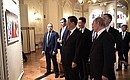 Перед началом торжественного вечера, посвящённого 70-летию установления дипломатических отношений между Россией и Китаем, Владимир Путин и Си Цзиньпин осмотрели совместную фотовыставку агентств ТАСС и Синьхуа.