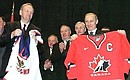President Putin and Jean Chretien receive 2002 T-shirts of Canadian and Russian ice hockey teams.