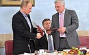 Президент Всероссийской федерации самбо Сергей Алексеев вручает Владимиру Путину орден Федерации самбо и отличительный золотой знак федерации.