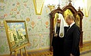 Vladimir Putin presents a gift, a painting of Moscow Kremlin churches, to Patriarch Kirill of Moscow and All Russia.