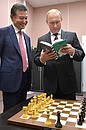 Vladimir Putin was presented with the chessboard on which Magnus Carlsen and Viswanathan Anand played their final match in the World Chess Championship and which they signed for the Russian President. With International Chess Federation President Kirsan Ilyumzhinov.