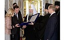 President Putin, German Federal Chancellor Gerhard Schroeder, his wife Doris Schroeder-Koepf and Patriarch of Moscow and All Russia Alexy II exchanging Christmas gifts.