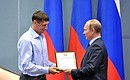 Vladimir Putin awards a commendation to Konstantin Gorovikov for his services to developing physical culture and sport.
