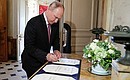 По окончании встречи с Президентом Швейцарии Ги Пармеленом Владимир Путин оставил запись в книге почётных гостей. Фото ТАСС
