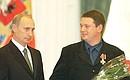 President Vladimir Putin conferring state awards on a group of Russian journalists. Oleg Groznetsky, Baltic office head of the ORT national television, receives the Order of Valour.