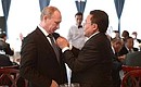 Президент Монголии Цахиагийн Элбэгдорж вручает Владимиру Путину юбилейную медаль «75-летие победы на Халхин-Голе».