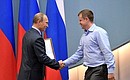 Vladimir Putin awards a commendation to Maxim Solovyov for his services to developing physical culture and sport.