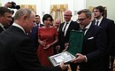 NTV staff presents Vladimir Putin with a commemorative postage stamp issued for the 25th anniversary of the television company.