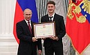 A letter of recognition for contribution to the development of Russia football and high athletic achievement is presented to Russia national football team player Anton Miranchuk.