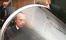 Visiting the Sukhoi Aviation Military Industrial Complex. President Putin examining a simulator for streamlining in-flight man-machine interface.