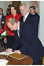President Vladimir Putin with German President Johannes Rau and his wife Christina. Signing the Visitors\' Book.