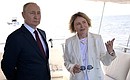 Vladimir Putin took part in a ceremony of raising the flags of the Russian Federation, the USSR and the Russian Empire on the coast of the Gulf of Finland. With Yelena Ilyukhina, Deputy General Director of Gazprom Neft and General Director of Gazprom Lakhta. Photo: Pavel Lisitsyn, RIA Novosti